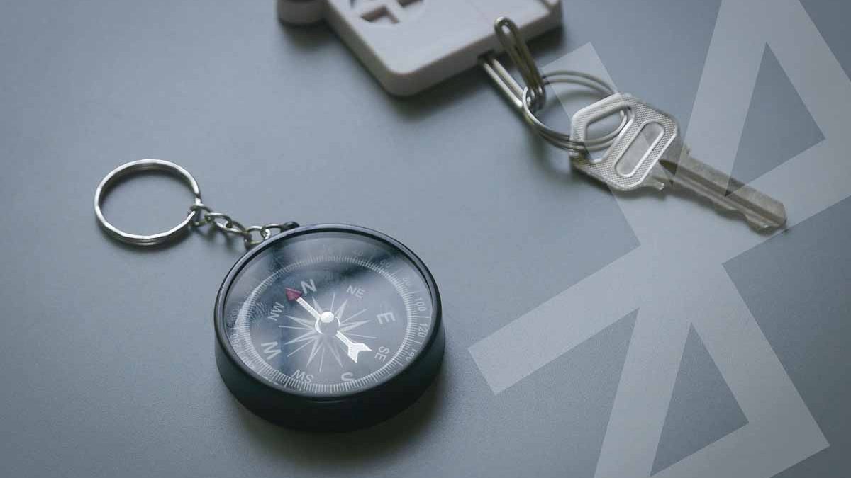 selective-focus-of-compass-and-key-holder-with-key-on-a-gray-background-bluetooth-key-finder